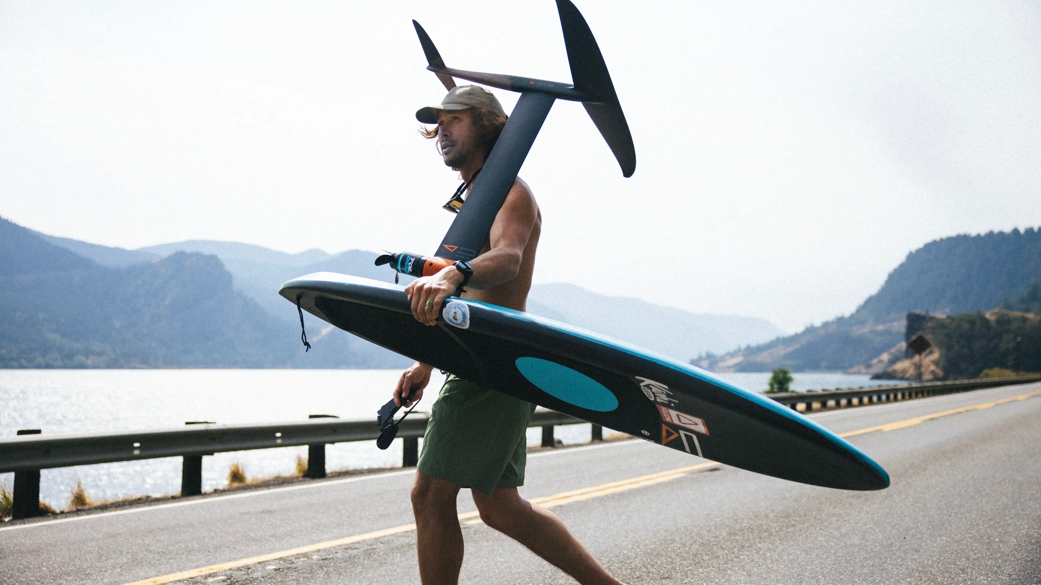 Hydrofoiler Josh Ku with his hydrofoil set up including the Kruzer RTS which is the best board for Foil Drive, walking across a road to foil in Hood River
