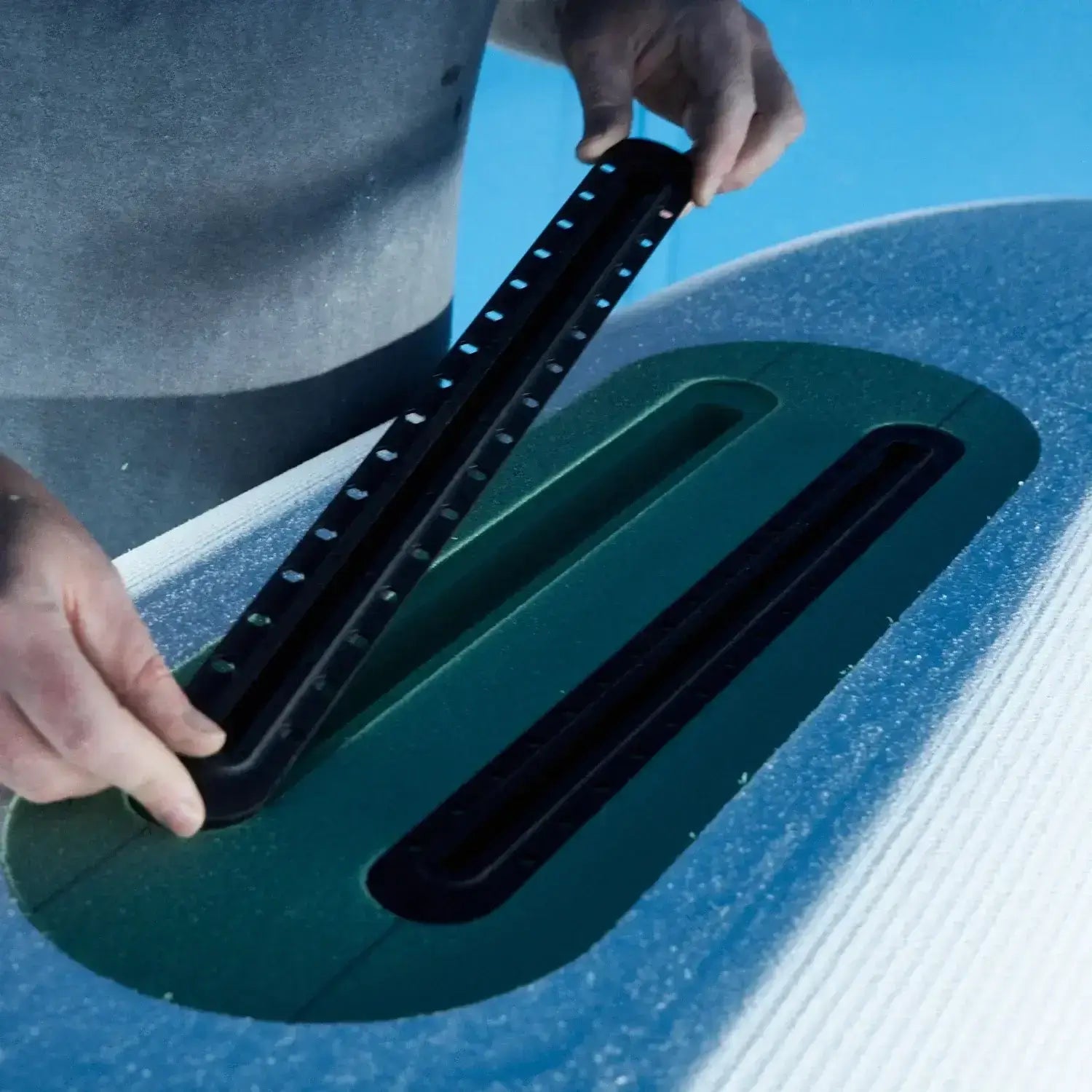 Close up of a surfboard builder using a Foil Tec jig kit to insert a foam insert into a foilboard foam blank