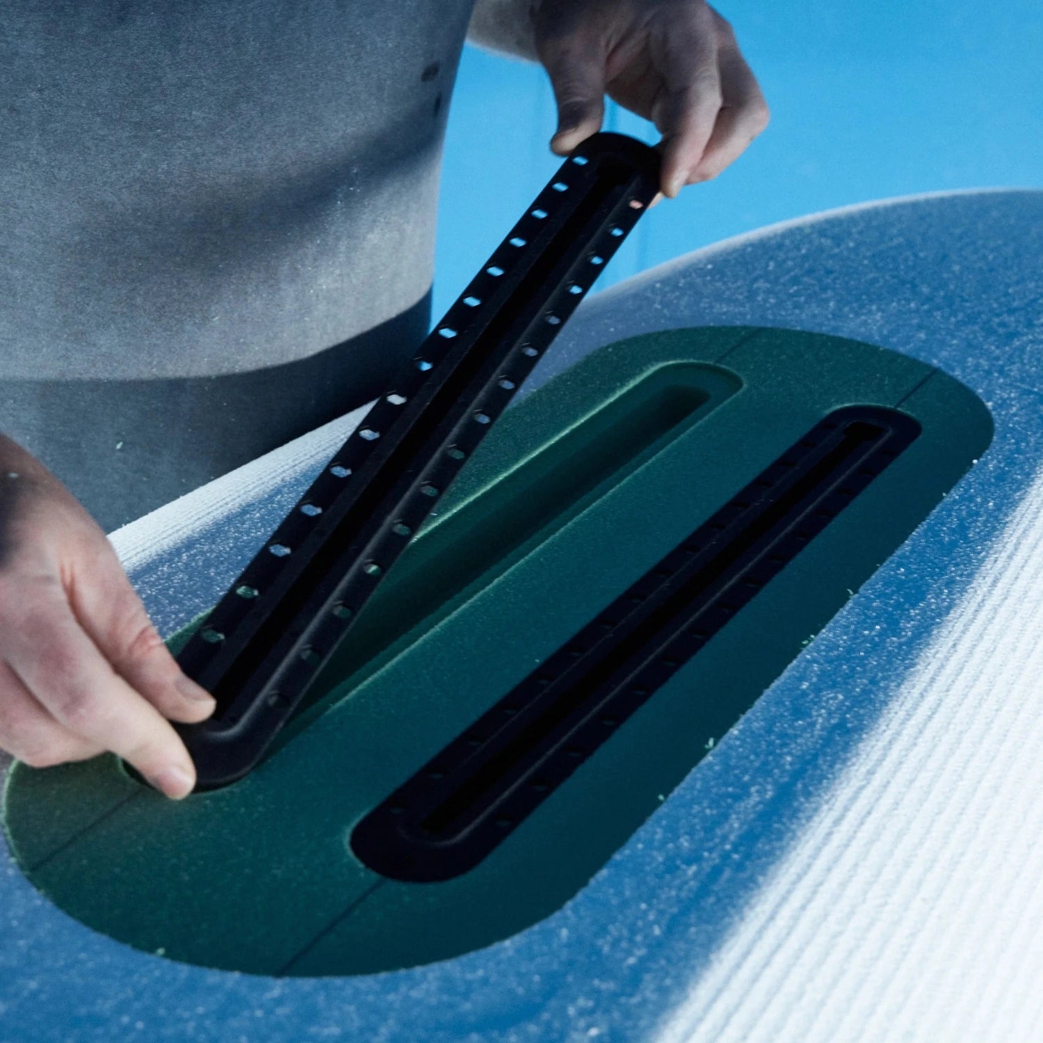 Close up of a surfboard builder using a Foil Tec jig kit to insert a foam insert into a foilboard foam blank