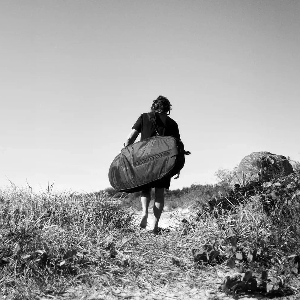 Lifestyle shot of a foiler holding a Foil Tec foilboard bag